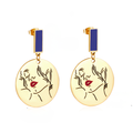 18k Gold earrings with face design and blue accents on a white background elazo