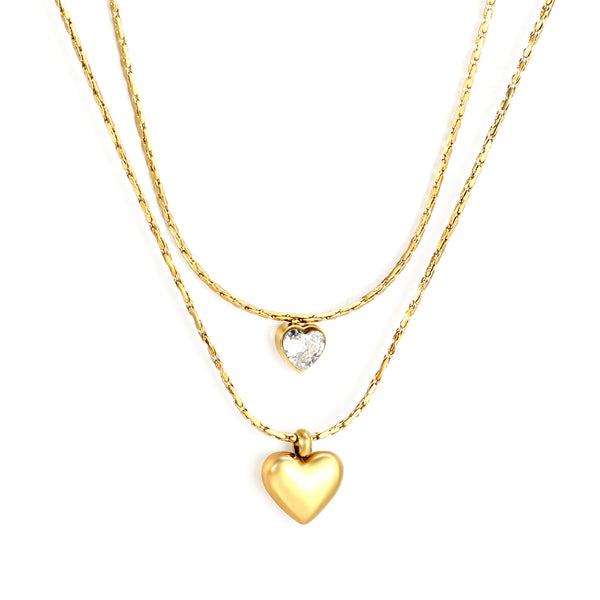Two gold heart-shaped pendants on gold chains against a white background