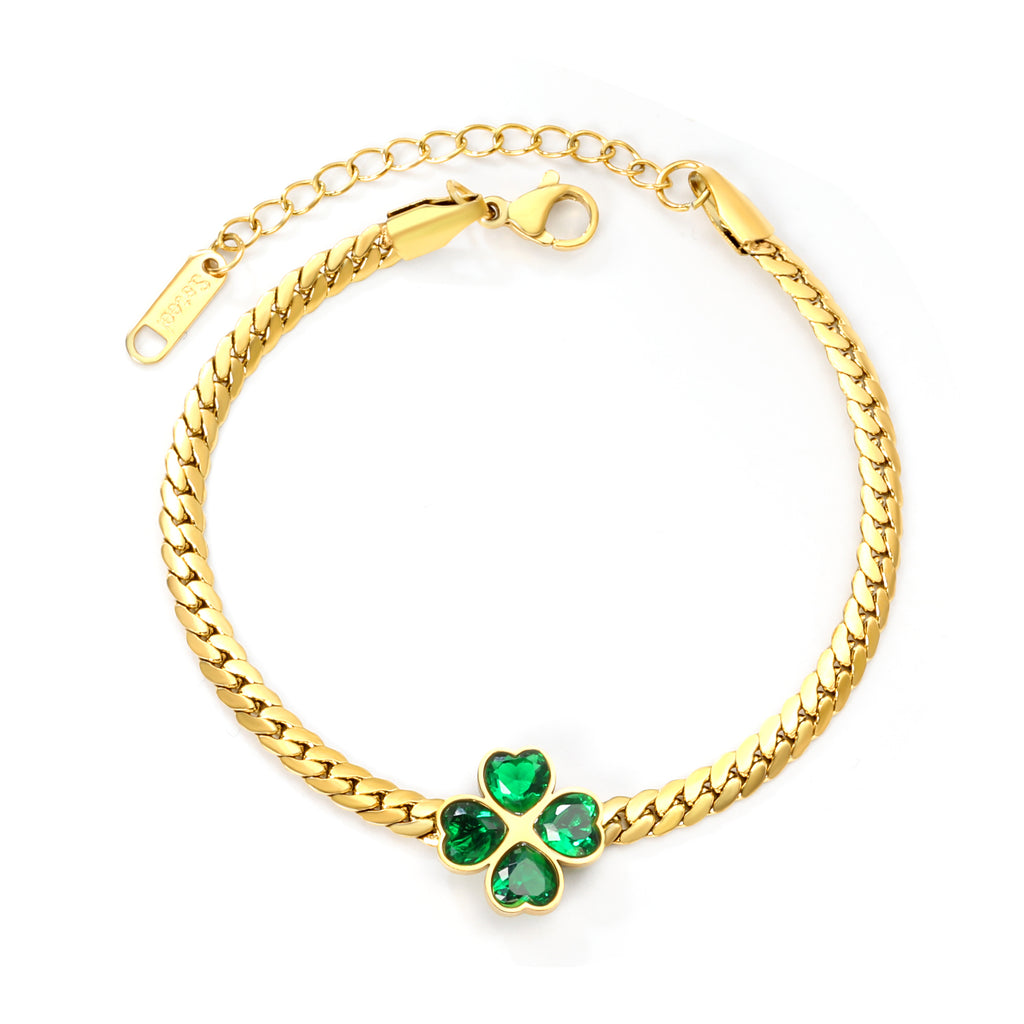 Gold bracelet with a green four-leaf clover charm on a white background