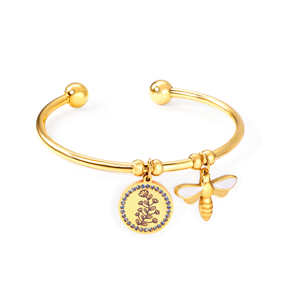 Gold bracelet with a bee and circular charm on a white background