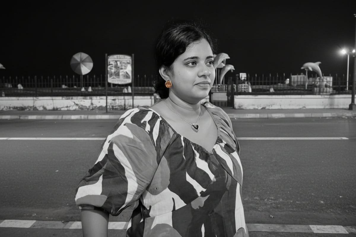 Woman in a colorful dress standing on a track at night